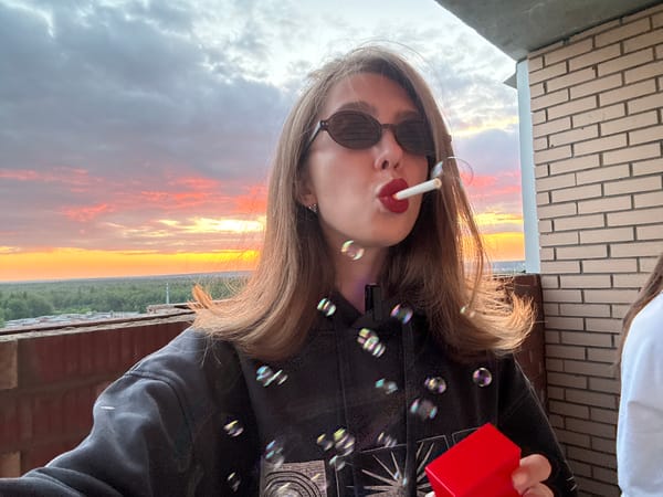Woman takes sunset selfies, smokes and blows bubbles on rooftop