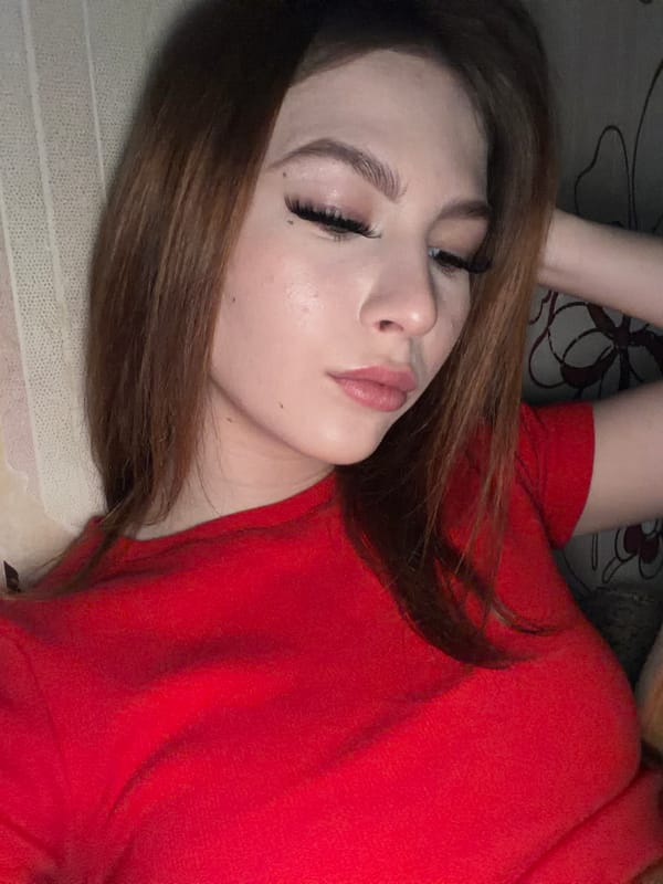 Woman in red top resting indoors in Noviy, Russia