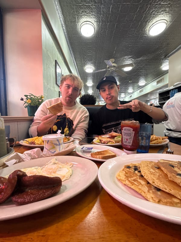 Two men enjoy breakfast spread at NYC restaurant