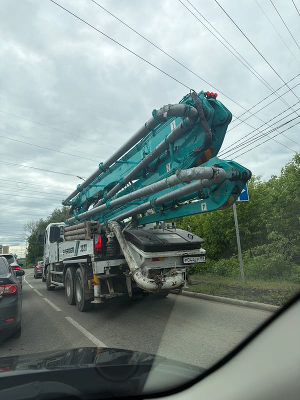 Woman takes car selfies near construction truck in Chaikovsky