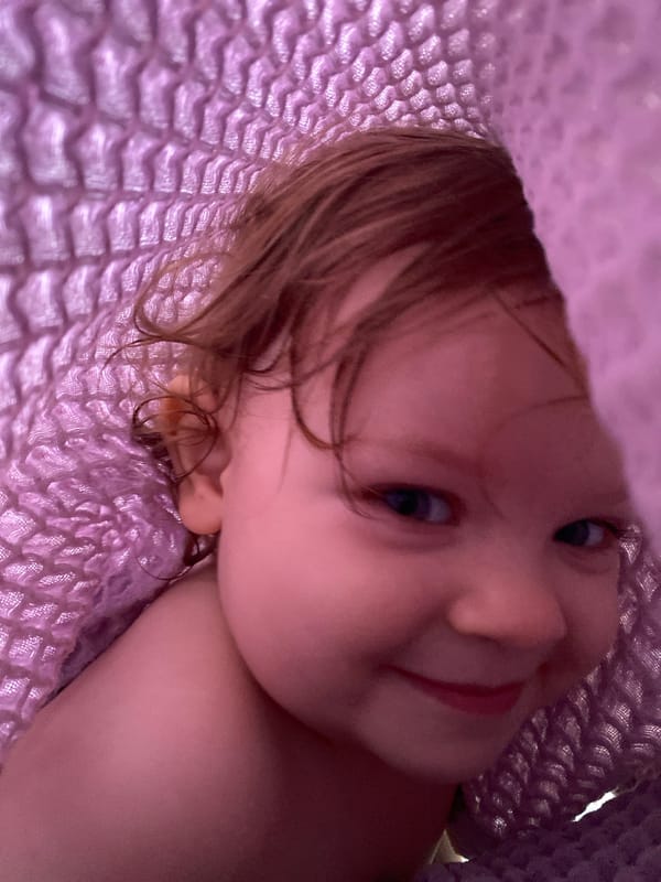 Child enjoys decorated chocolate strawberries under purple blanket