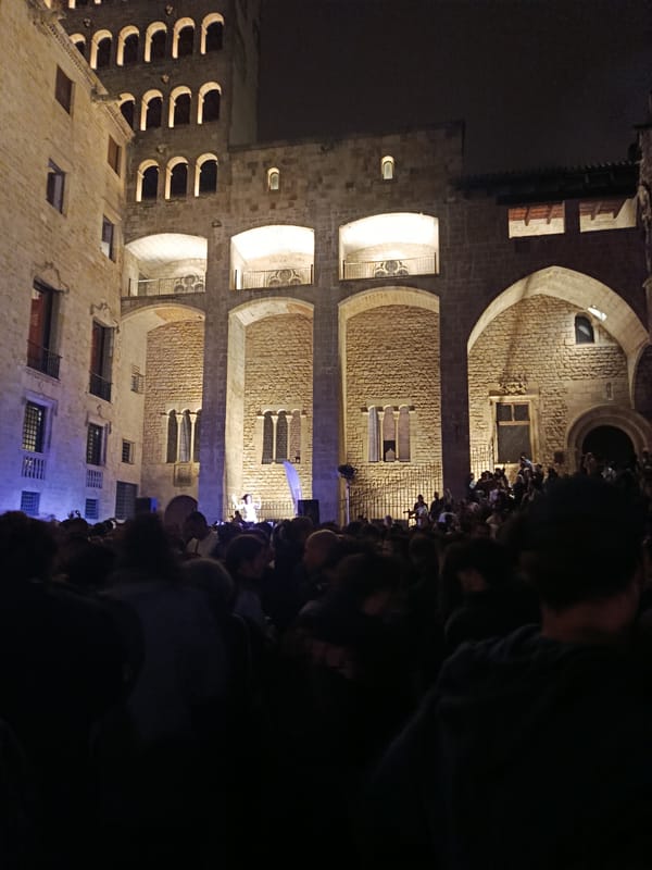 Nighttime crowd gathers in historic stone courtyard