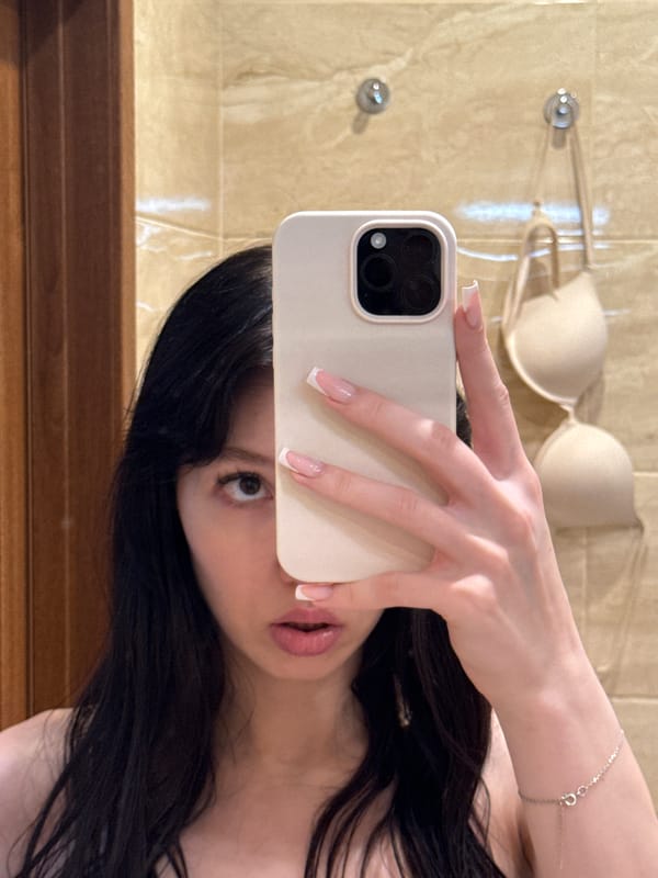 Bathroom mirror selfie, phone raised, face partially obscured