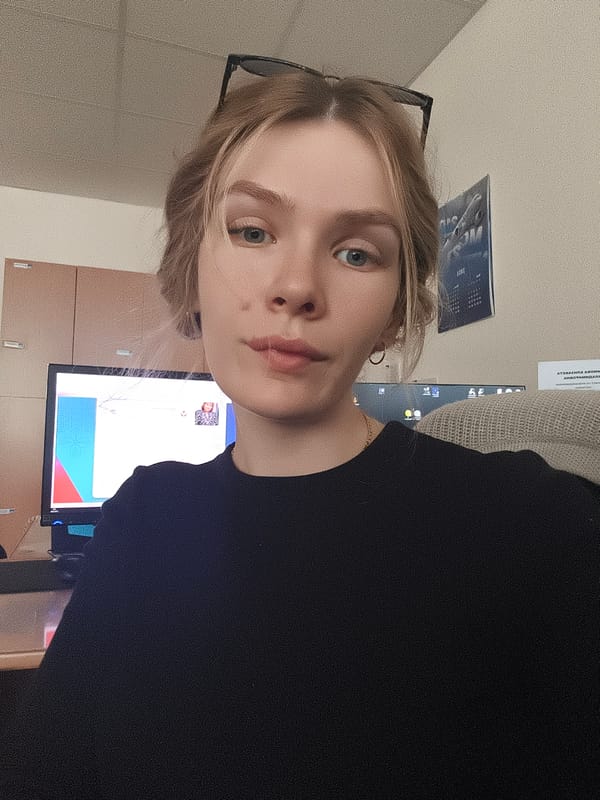 Young woman photographed indoors wearing glasses and black shirt