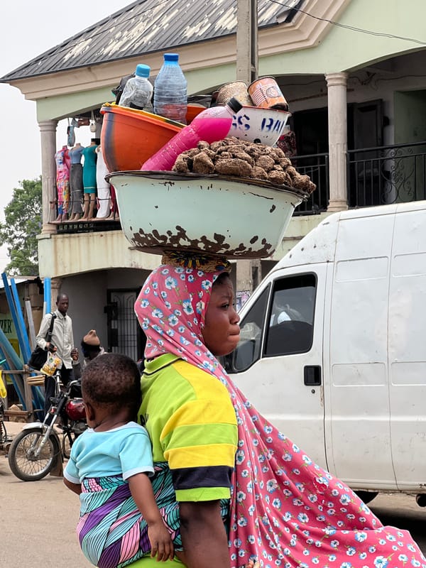 Woman carries goods on head tray in Bukuru Nigeria