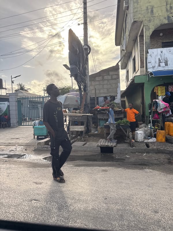 Young man stands near market in Ado, Nigeria