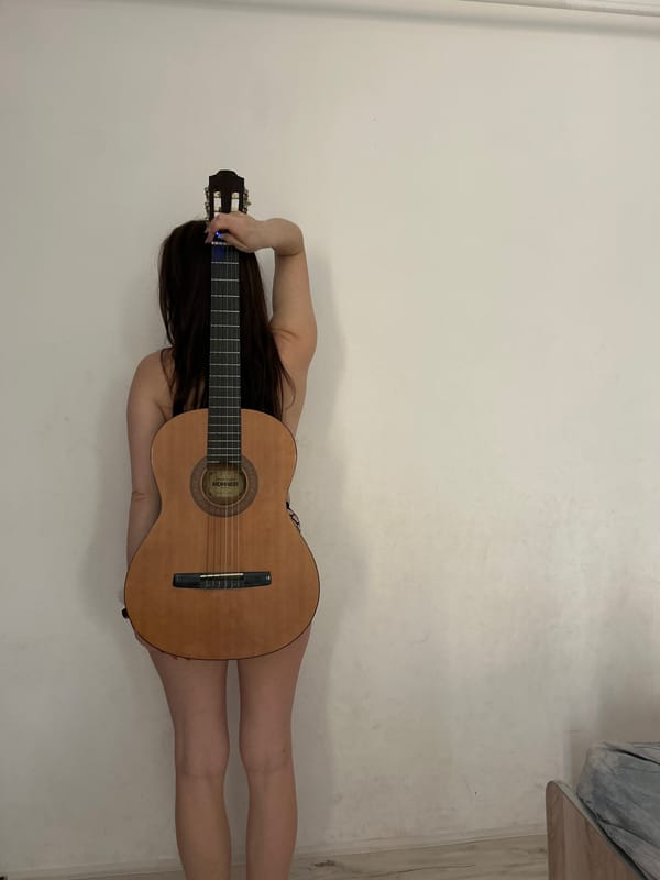 Woman poses with guitar in artistic photo session, Rusalevka