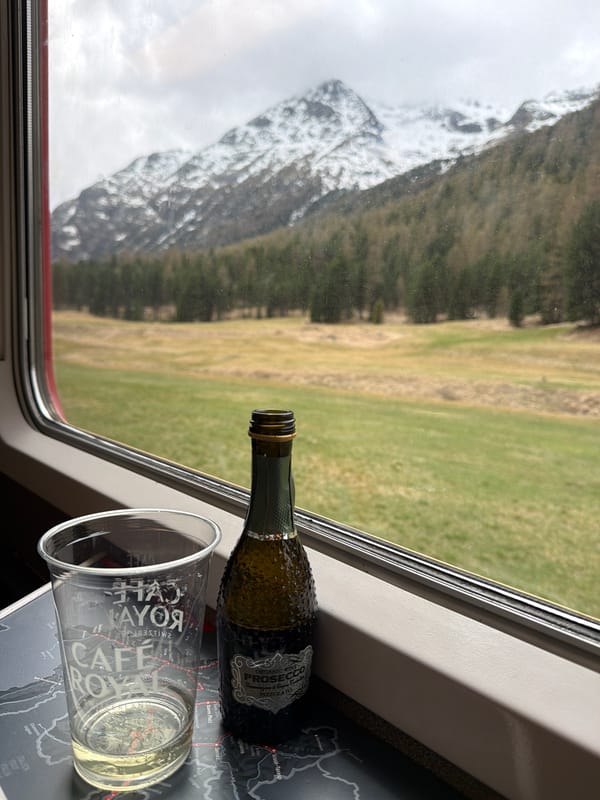Train passenger enjoys Prosecco amid Swiss Alpine scenery