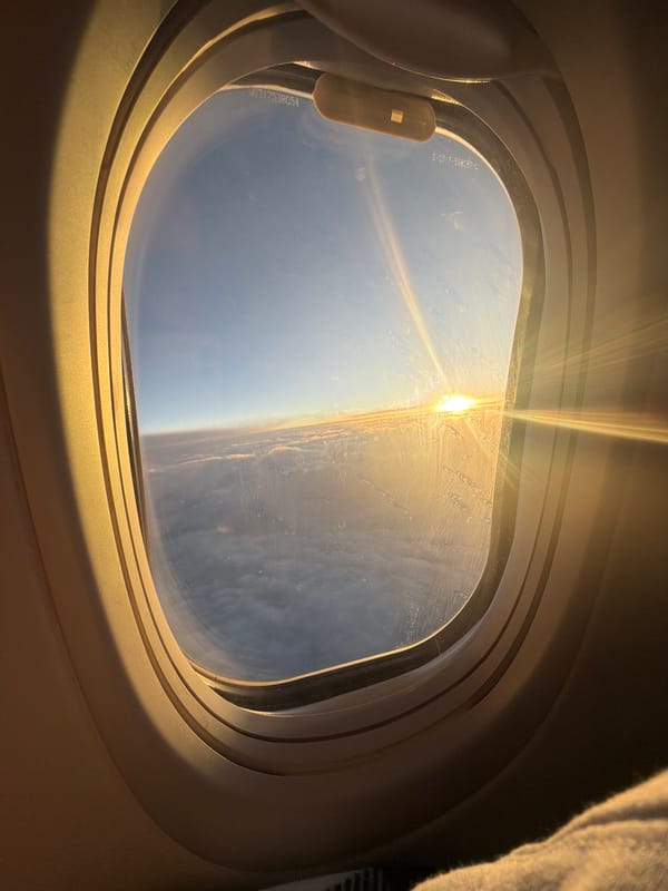 Passenger documents sunrise flight over Russian cloudscape from airplane window