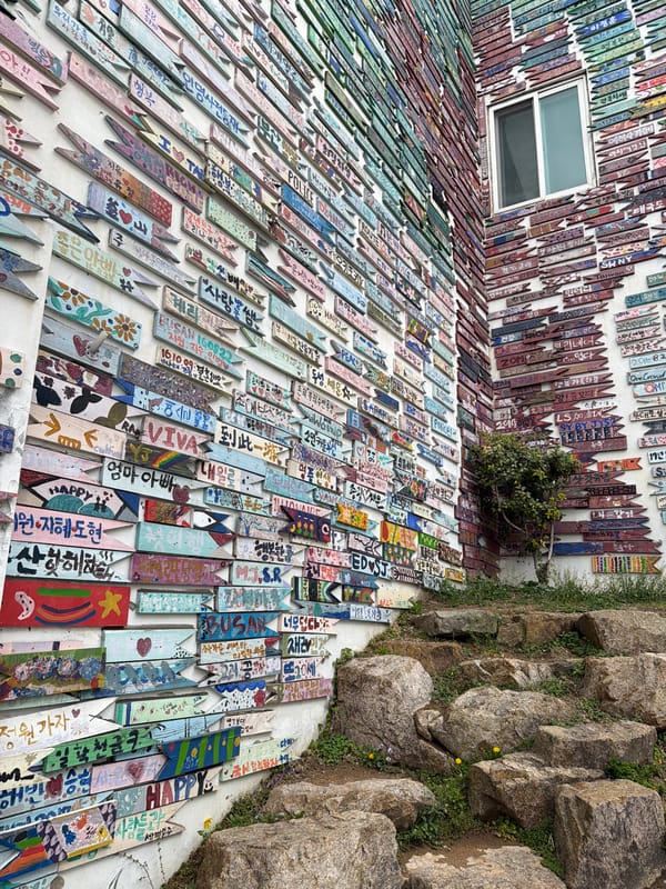 Tourists photograph colorful street art installations in Busan