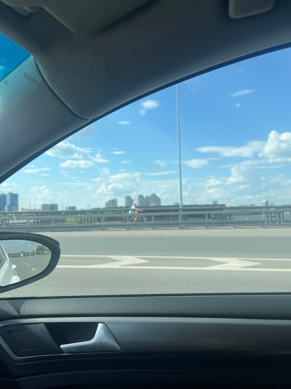 Cyclist crosses bridge in Kazan under cloudy skies