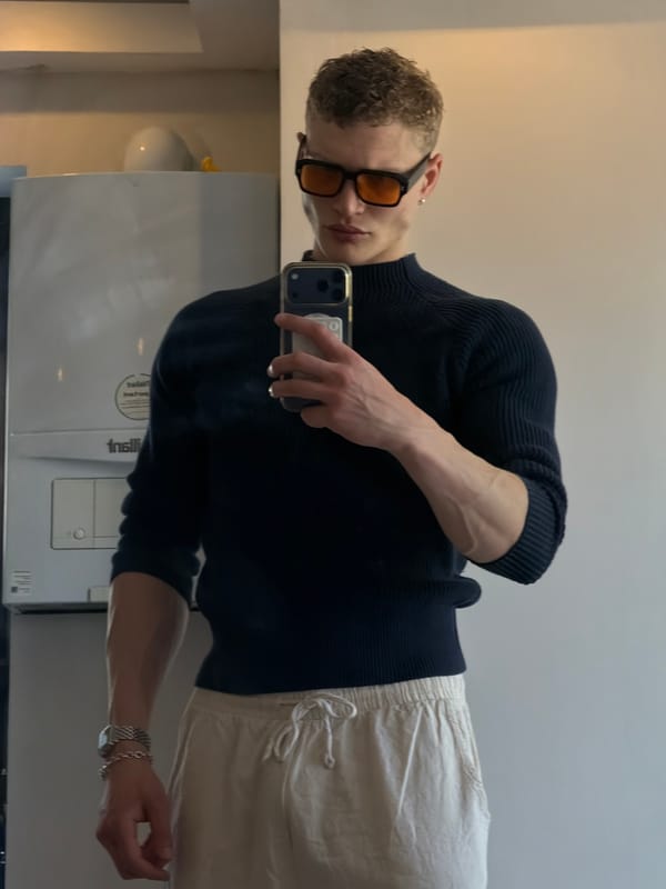 Person takes mirror selfie in London wearing orange sunglasses