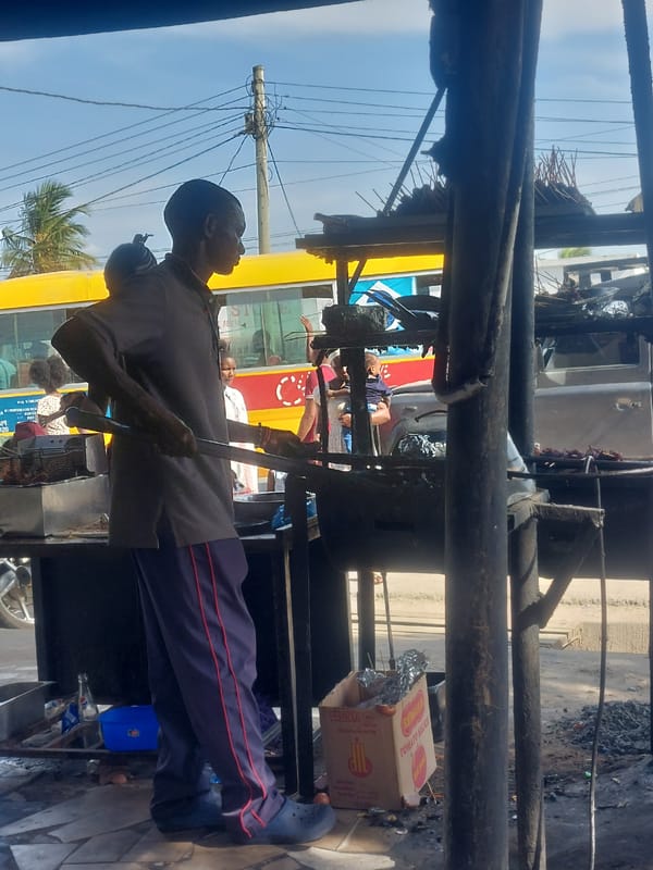 Street food vendors serve customers at roadside eateries in Dar es Salaam