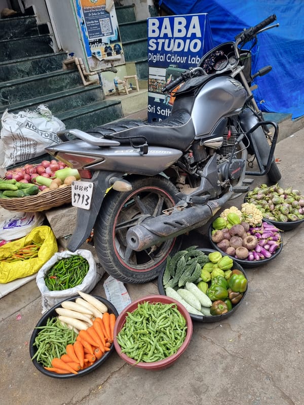 Street vendor serves fresh juice from motorcycle stand in Puttaparthi