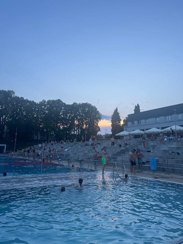 Crowded outdoor pool at golden hour, lanes full