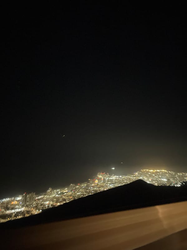 Nighttime city skyline photographed from elevated vantage point