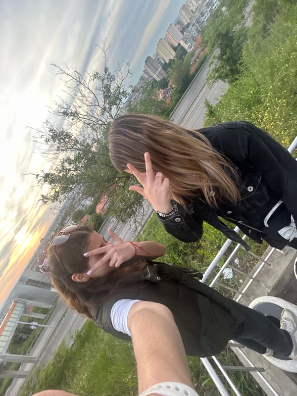 Women pose on Ruse bridge during golden hour sunset