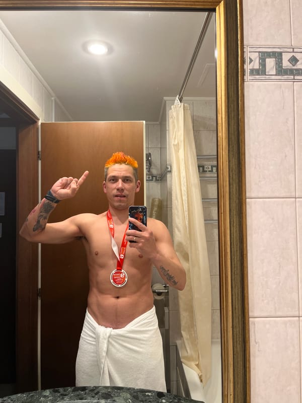 Orange-haired man takes towel selfie with medal in Moscow bathroom