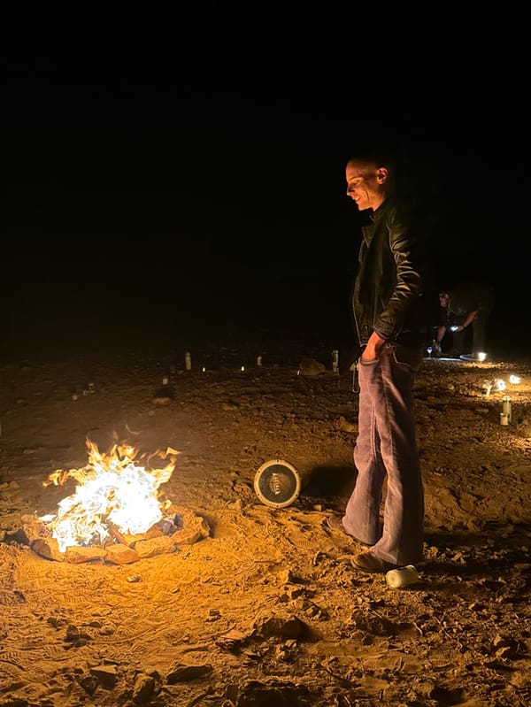 Man tends multiple campfires in Mizpe Ramon desert area