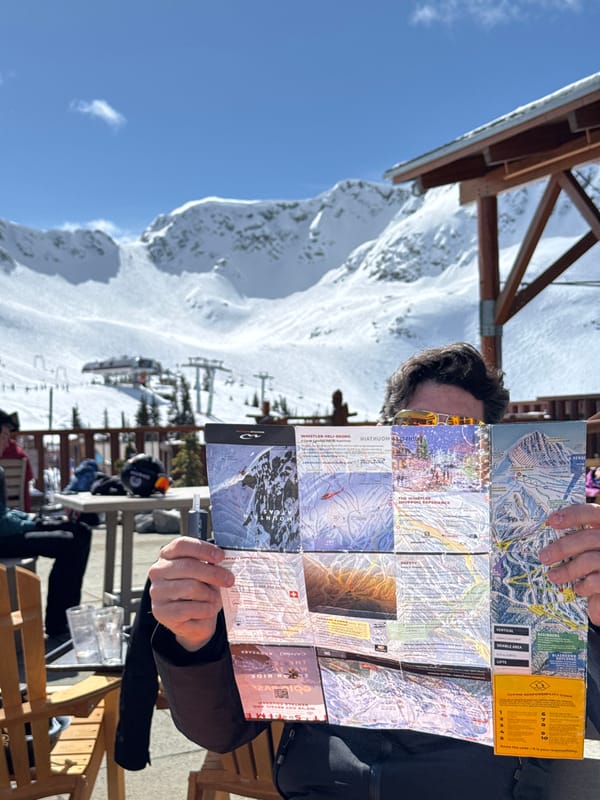 Tourists study trail maps, pose at Whistler ski resort