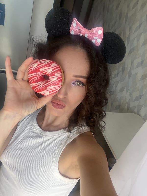Woman with Minnie Mouse ears holds decorated donut in Kazan