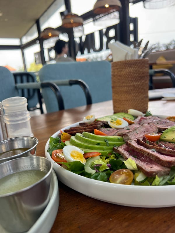 Brunch at a tropical Mengwi cafe with food and a relaxed dog