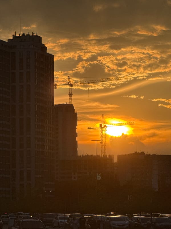 Sunset hour in the city: skyline, cafe interior, sidewalk dusk