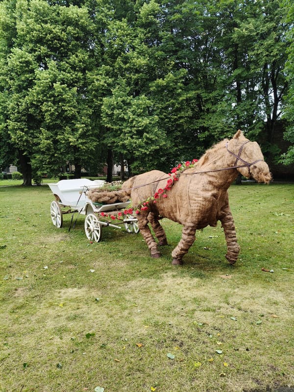 Straw horse sculpture with floral decorations in Ventspils