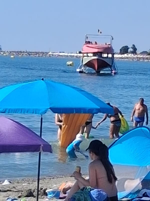 Crowded sunny beach with colorful umbrellas packed shoreside
