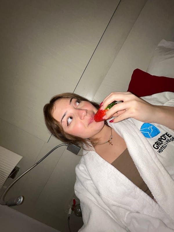 Woman poses with strawberries in Spanish hotel room