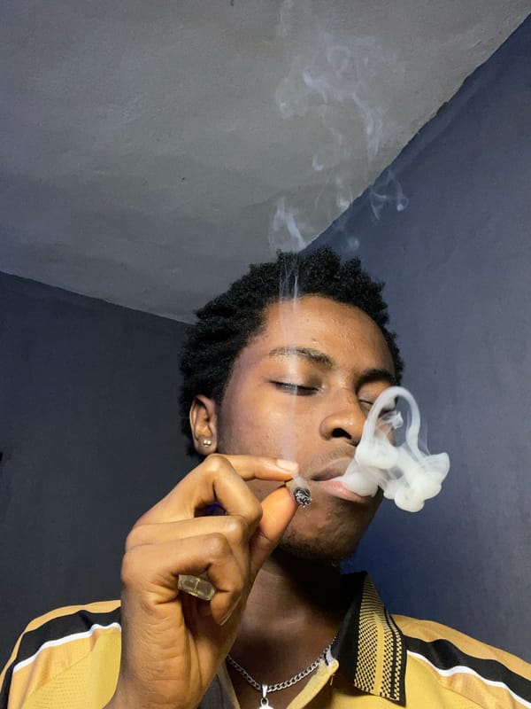 Young man photographed smoking indoors in Nkpor, Nigeria