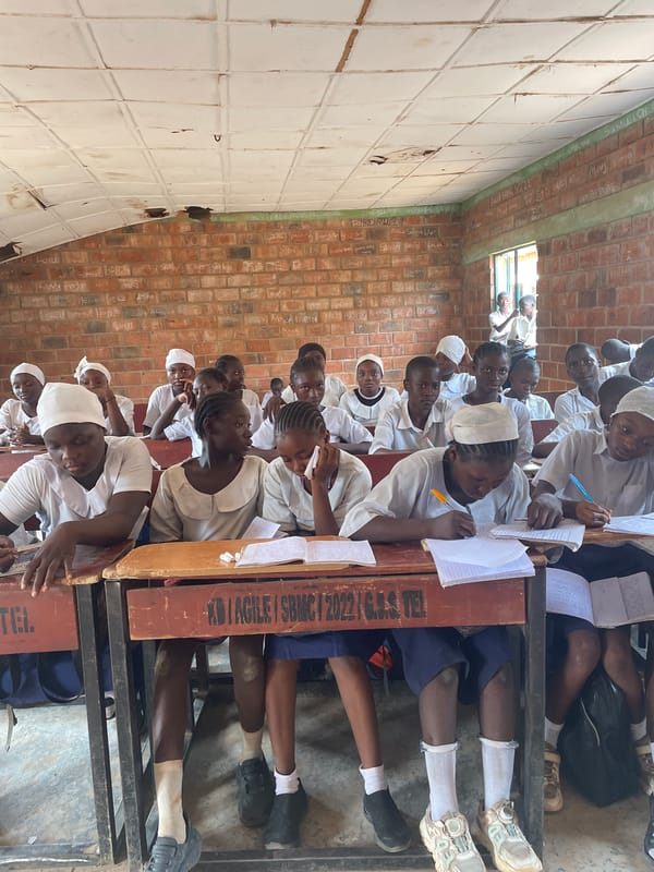 Students in white uniforms attend class in Television, Nigeria