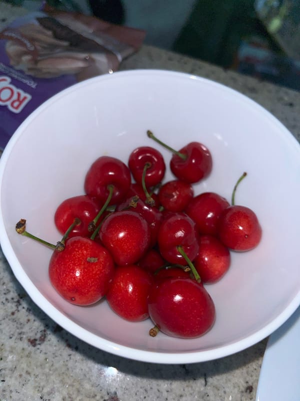 Young man enjoys bowl of fresh cherries in Zlatograd