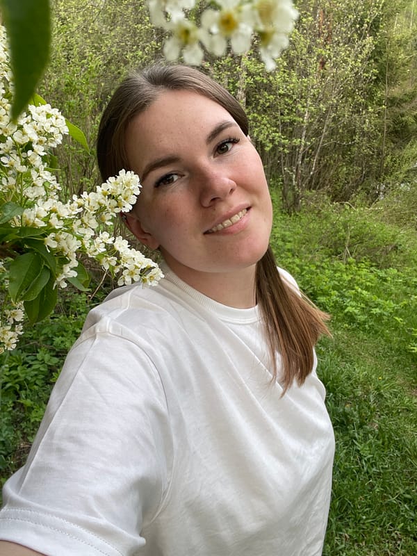 Woman poses for outdoor photo session amid flowers in Zhigalki