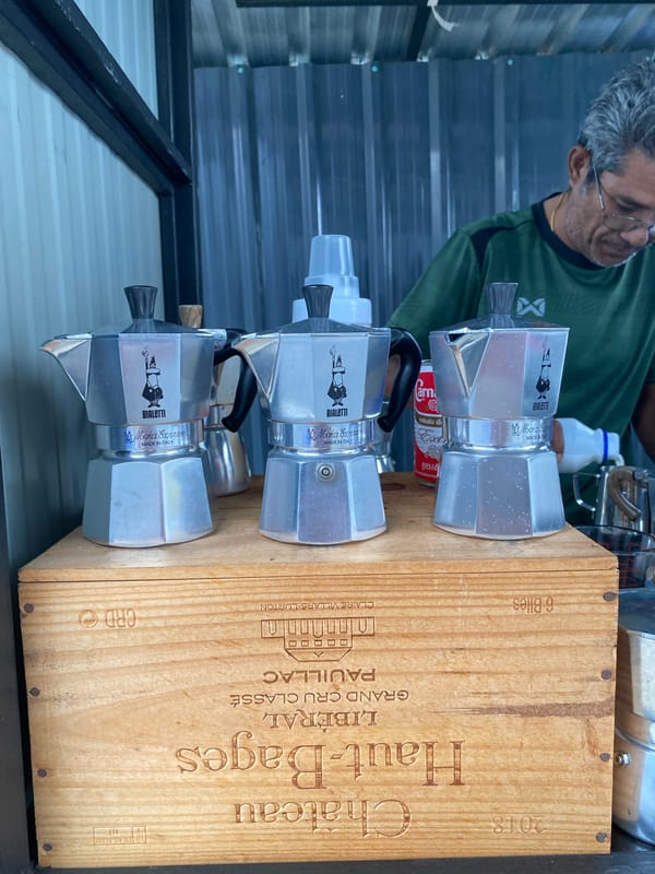 Coffee vendor serves customers during rainy morning in Thailand