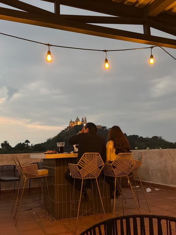 Couple photographs historic church from Cholula rooftop