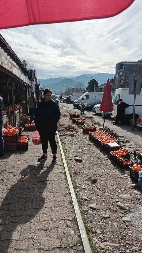 Woman walks through street market in Batumi, Georgia