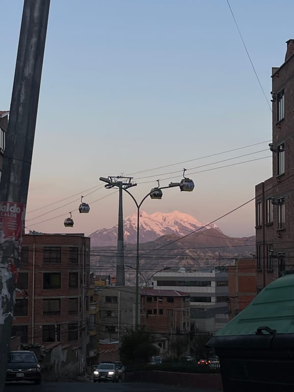 Cable cars operate above La Paz cityscape with mountains
