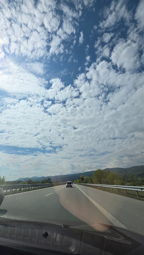 Vehicle travels highway near Strumyani, Bulgaria under cloudy skies