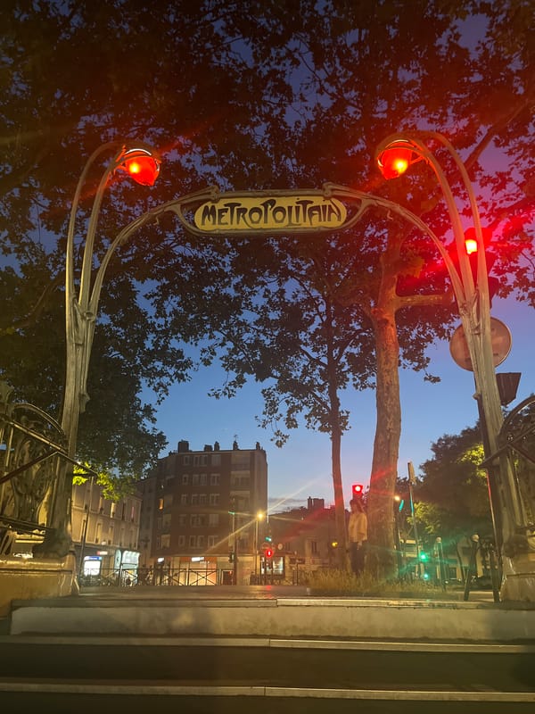 Abbesses Métro entrance glows at night in Montmartre