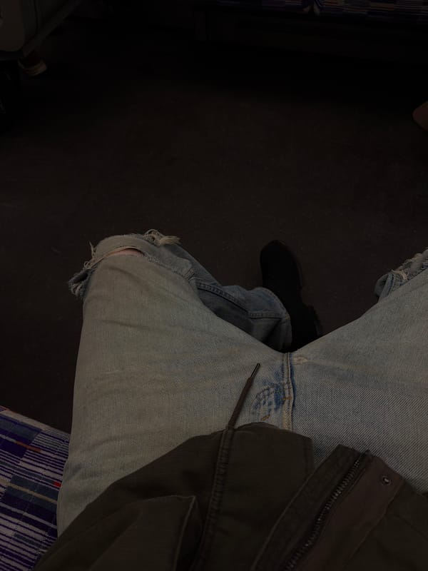 Person in ripped jeans observed seated indoors in London