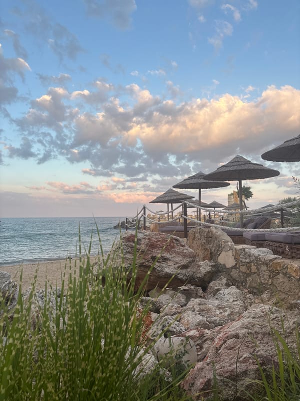 Beachfront resort at dusk: statues, castle architecture, and sea views