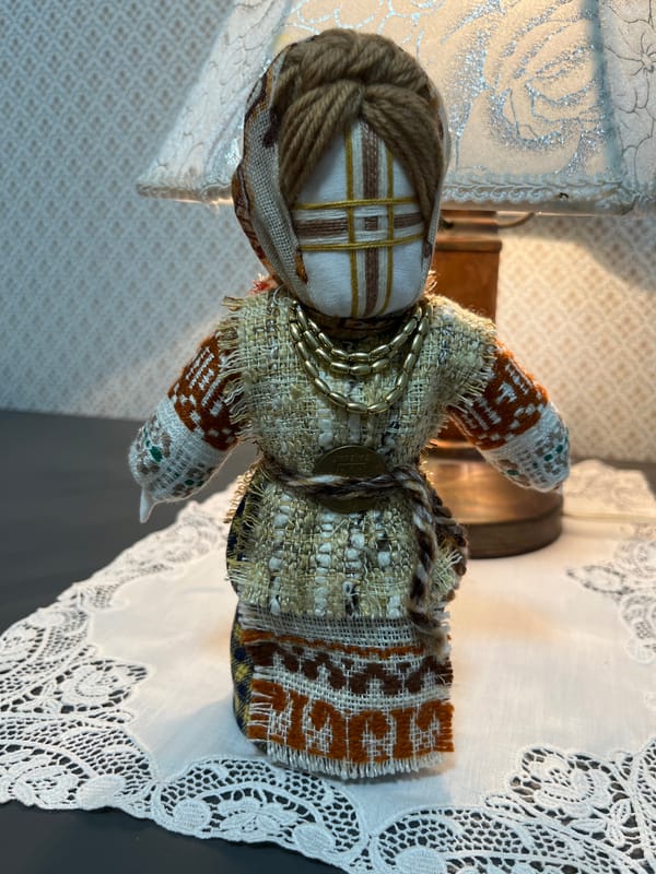 Decorative home objects: folk doll, houseplant, and patterned fabric