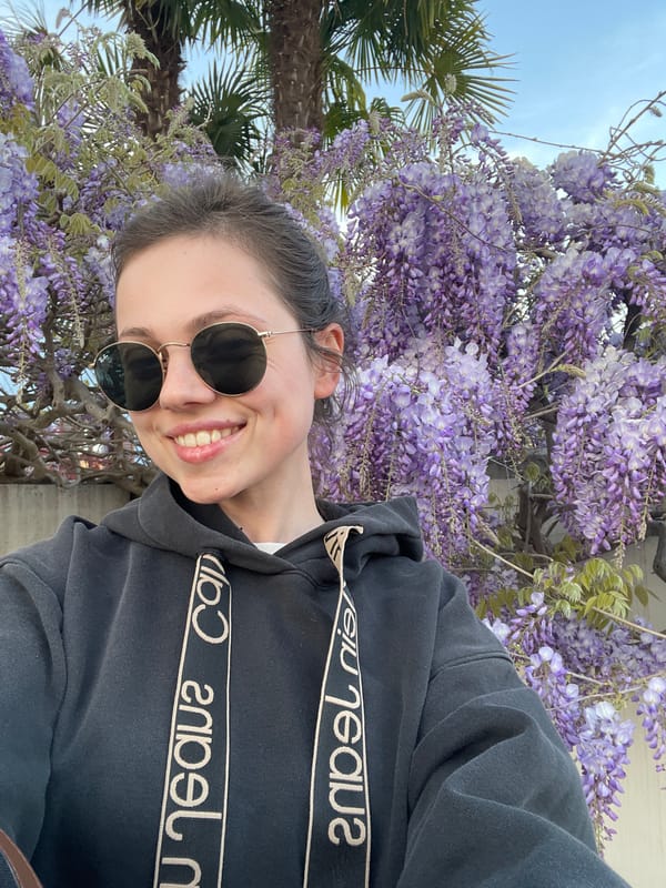 Woman poses with spring wisteria blooms in northern Italy