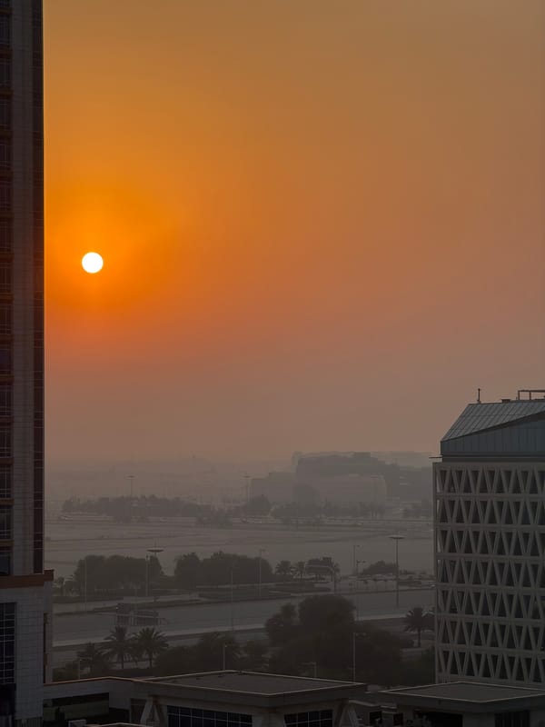 Lusail skyline glows under a hazy golden-hour sun