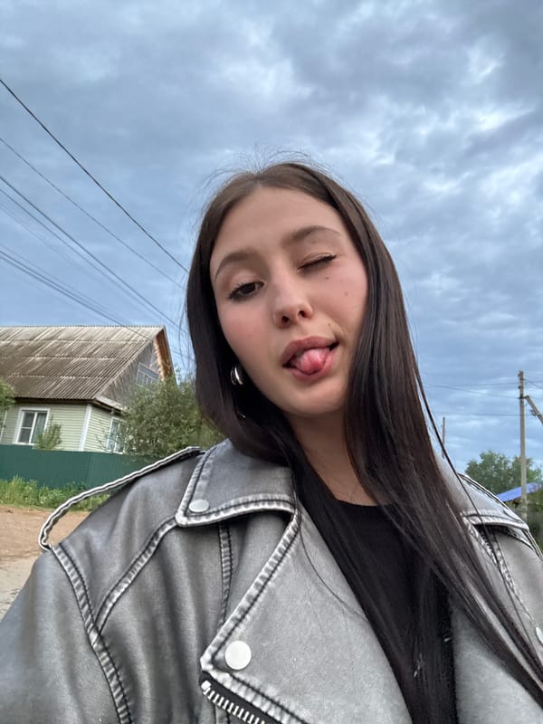 Woman makes playful gesture outdoors in Russian village