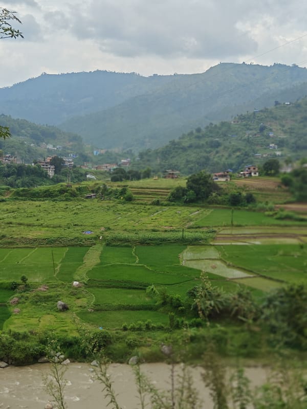 Terraced fields and a muddy river valley in rural Thakre, Nepal