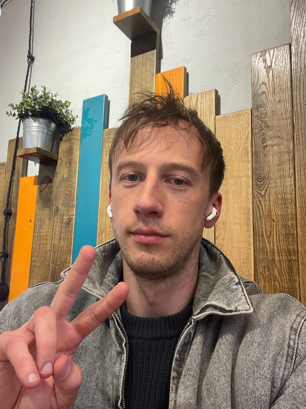 Man takes indoor selfie wearing earbuds in Murino