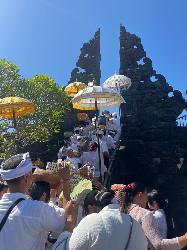 Ceremonial procession ascends temple steps in Bali