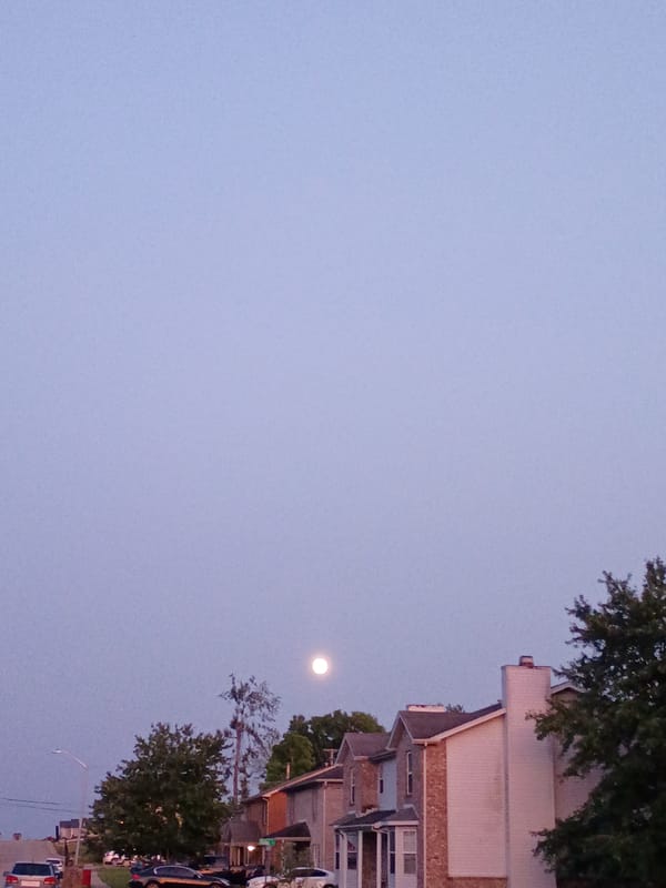 Full moon rises over quiet Nicholasville streets at dusk